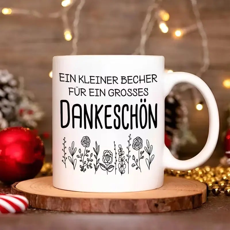 Eine hochwertige 11-Unzen-Keramik-Kaffeetasse mit stilvollem weißem Design, floralen Mustern und einem deutschen Dankesausdruck. Nur handwaschbar, geeignet für wiederholten Gebrauch und ein tolles Geschenk.